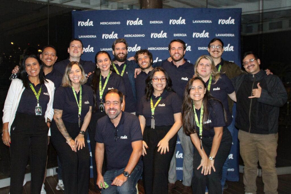 Equipe da Roda Conveniência em frente ao painel da marca na primeira edição do Roda Conecta, no Village Mall, Rio de Janeiro